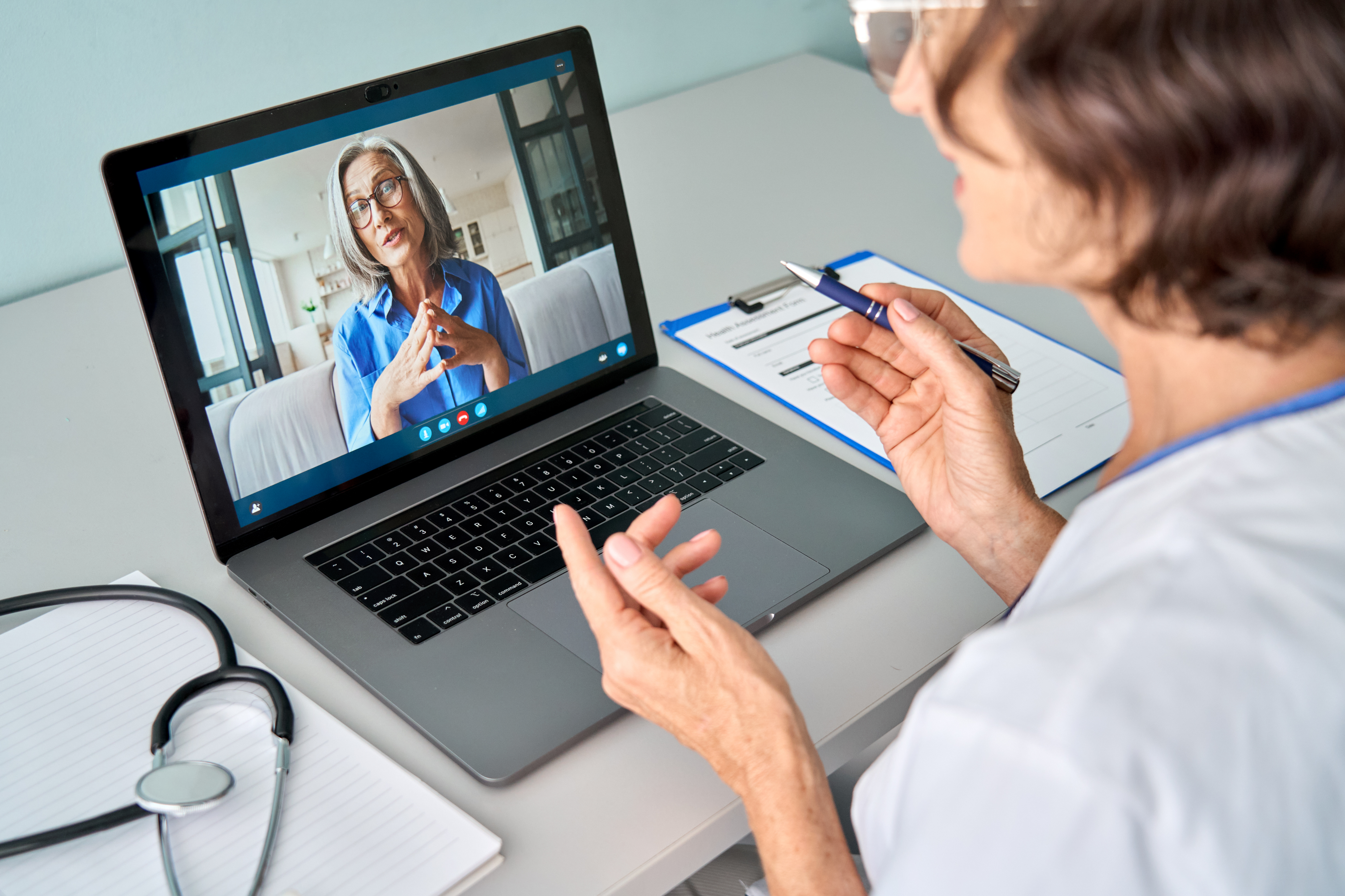 Female doctor consulting patient via virtual video call visit using laptop